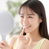 虫歯治療と審美歯科の順番を知って歯並びを確認する女性