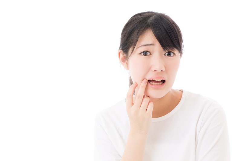 歯の鋭利な角や不適合な被せ物が、口の粘膜を刺激している様子のイラスト