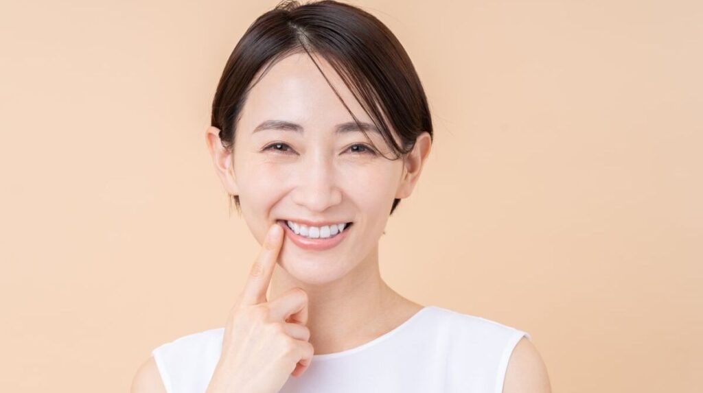 東京・銀座の街並みを背景に、バランスの取れた美しい口元で自信を持って微笑む女性