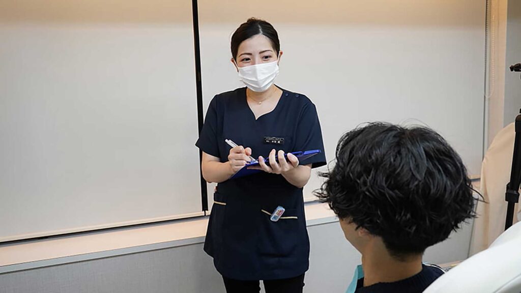 東京・銀座の審美歯科で、歯を大きくする治療法の比較説明を受ける様子