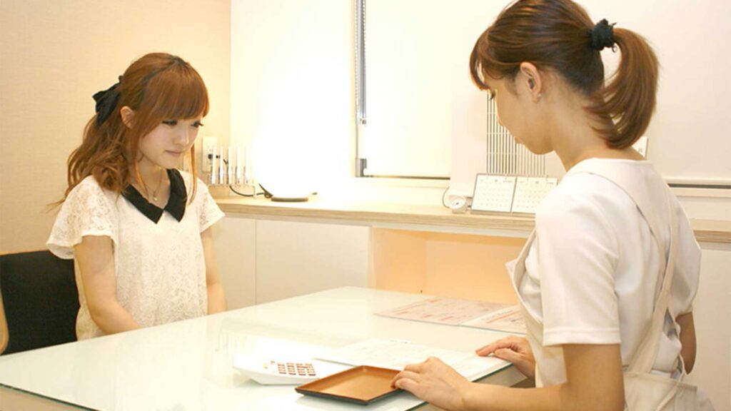 東京・銀座の審美歯科で、オーダーメイドのホームホワイトニングキットを受け取る女性