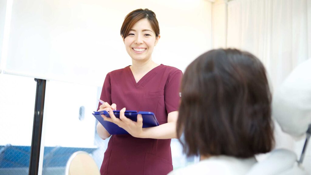 東京・銀座の審美歯科で、歯の白さを守るためのアドバイスを受ける女性